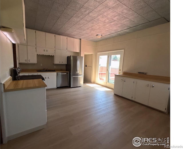 619 Curtis St, Brush, CO 80723 - kitchen featuring appliances with stainless steel finishes, white cabinets, and light wood-style flooring