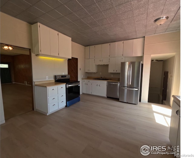 619 Curtis St, Brush, CO 80723 - kitchen with appliances with stainless steel finishes, light wood-style floors, and white cabinets