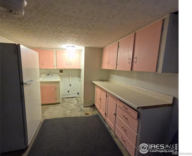619 Curtis St, Brush, CO 80723 - kitchen featuring freestanding refrigerator, washer / dryer, and light countertops