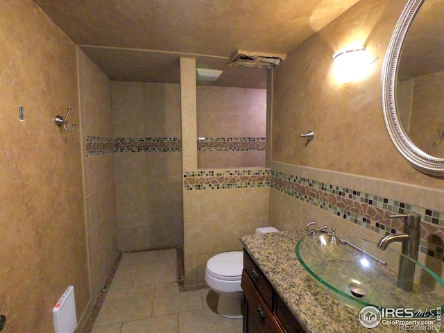 619 Curtis St, Brush, CO 80723 - bathroom featuring vanity, tile patterned flooring, tile walls, and a tile shower