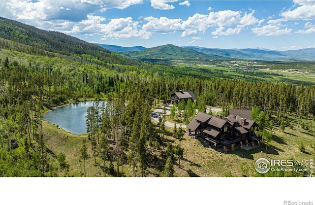 bird's eye view featuring a forest view and a water and mountain view