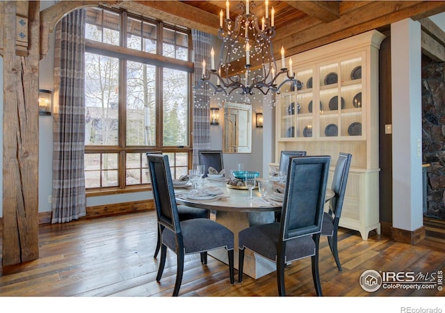 dining space with a chandelier, a wealth of natural light, beamed ceiling, and hardwood / wood-style flooring