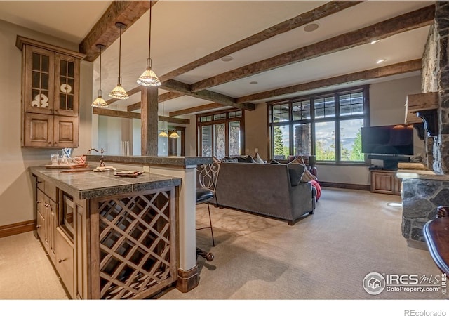 kitchen with open floor plan, beamed ceiling, a peninsula, and a kitchen bar