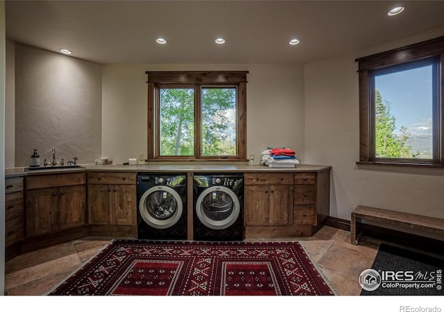 laundry room with recessed lighting, a sink, baseboards, cabinet space, and washer and clothes dryer