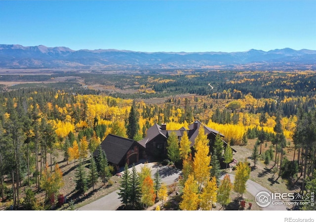 aerial view featuring a mountain view and a view of trees