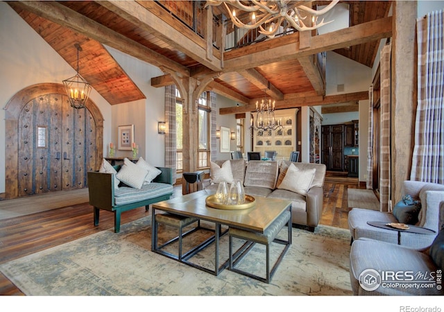 living area with wooden ceiling, a chandelier, arched walkways, and beamed ceiling