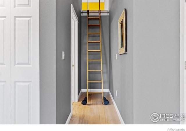 hallway with baseboards and wood finished floors