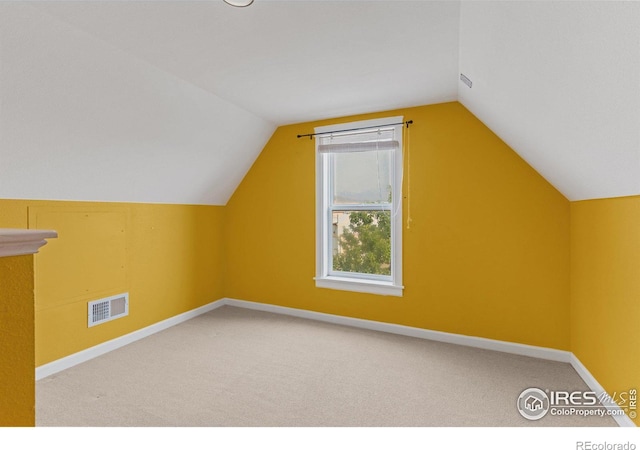 bonus room featuring carpet floors, visible vents, vaulted ceiling, and baseboards