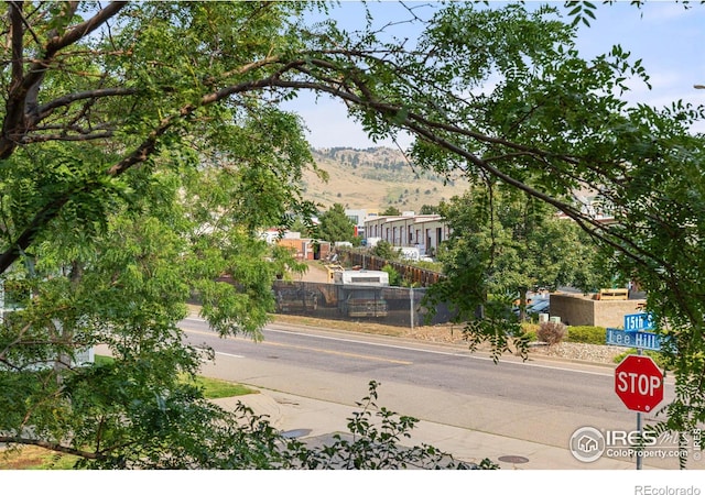 view of road with curbs, traffic signs, and a mountain view