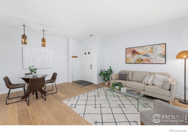 living area featuring baseboards and wood finished floors