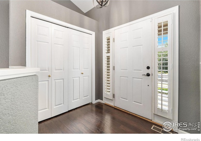 foyer entrance with lofted ceiling and dark hardwood / wood-style flooring