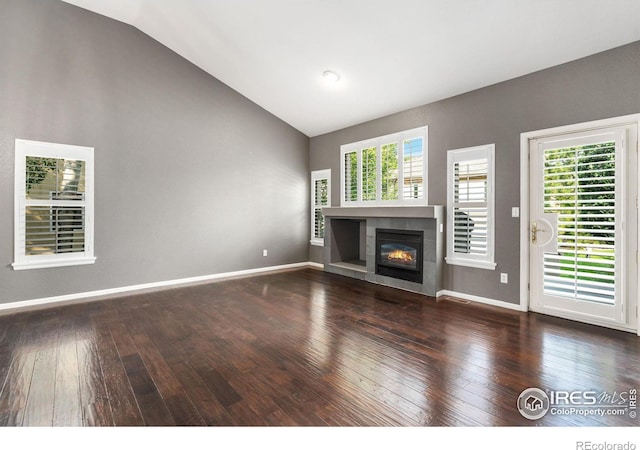 unfurnished living room featuring hardwood / wood-style flooring, vaulted ceiling, and a tile fireplace