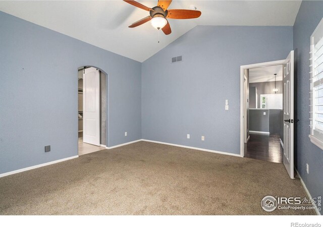 spare room featuring wood-type flooring, high vaulted ceiling, and ceiling fan