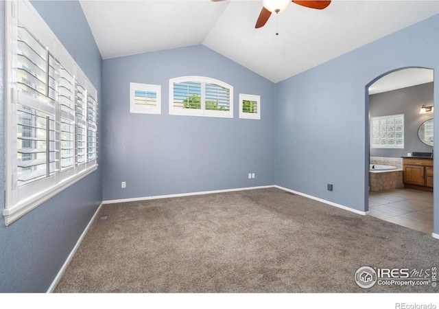 tiled spare room featuring ceiling fan and lofted ceiling