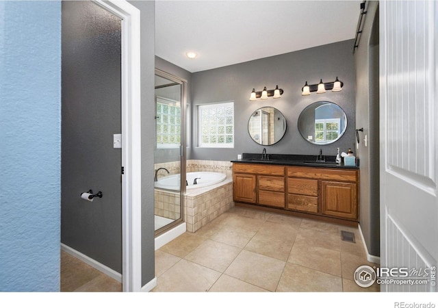 bathroom featuring tile patterned flooring, double sink vanity, and plus walk in shower