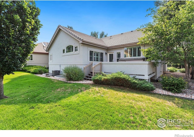 back of property featuring cooling unit, a yard, and a wooden deck