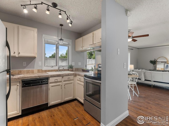 kitchen featuring sink, decorative light fixtures, stainless steel appliances, and white cabinets