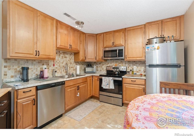 3300 Madison Ave, Boulder, CO 80303 - kitchen featuring light countertops, a sink, stainless steel appliances, visible vents, and decorative backsplash