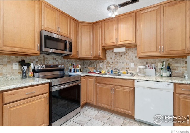 3300 Madison Ave, Boulder, CO 80303 - kitchen with light tile patterned floors, decorative backsplash, a sink, visible vents, and appliances with stainless steel finishes