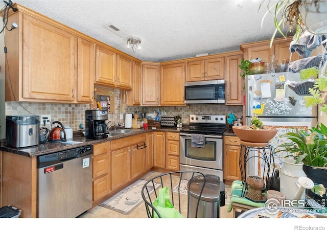 3300 Madison Ave, Boulder, CO 80303 - kitchen featuring a sink, stainless steel appliances, backsplash, and dark countertops