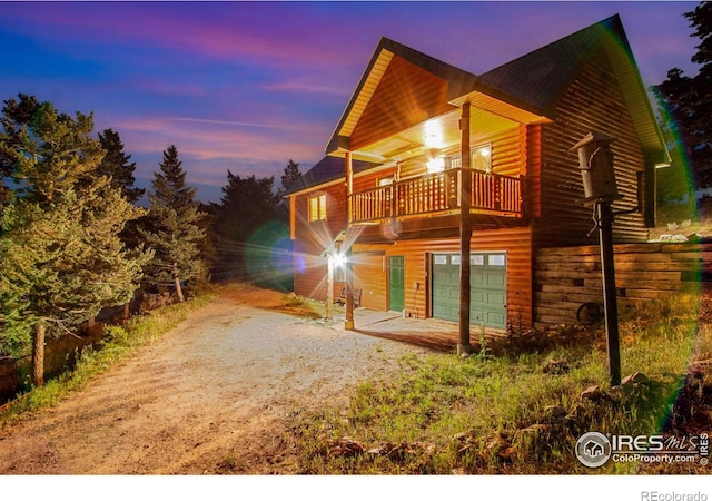 property exterior at dusk featuring a balcony