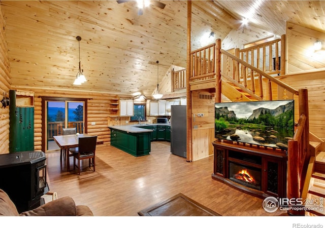 679 Mount Massive Dr, Livermore, CO 80536 - living room with light wood-style flooring, log walls, wood ceiling, high vaulted ceiling, and a wood stove