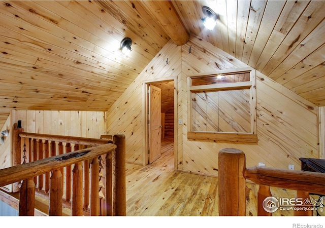 additional living space featuring hardwood / wood-style floors, wood walls, wooden ceiling, and lofted ceiling