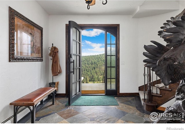 entrance foyer featuring stone tile flooring and baseboards