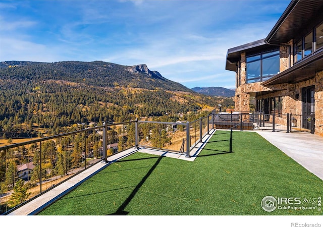 view of yard featuring fence and a mountain view