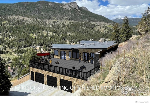 view of front facade featuring a garage, stone siding, and a mountain view