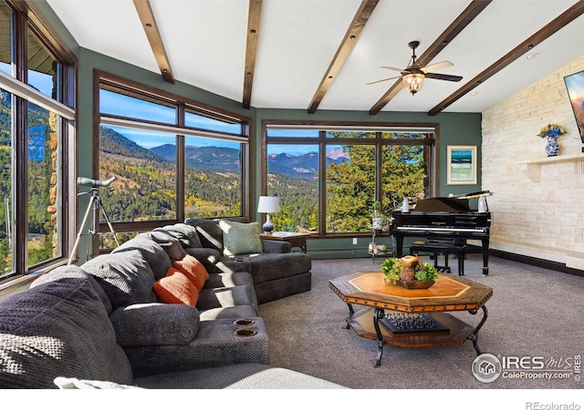 carpeted living area with a wealth of natural light and vaulted ceiling with beams