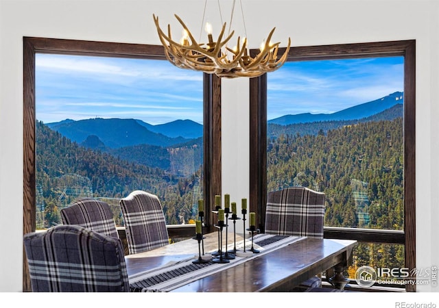 dining room featuring plenty of natural light, a mountain view, and an inviting chandelier