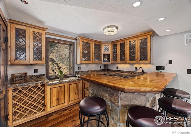 bar featuring dark wood-style floors, indoor wet bar, visible vents, and recessed lighting