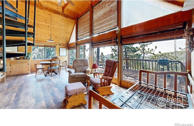 living room featuring wooden walls, wood ceiling, hardwood / wood-style floors, and high vaulted ceiling