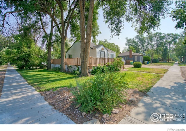 view of side of home featuring a wooden deck and a yard