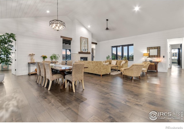 dining area with high vaulted ceiling, dark hardwood / wood-style floors, and a chandelier