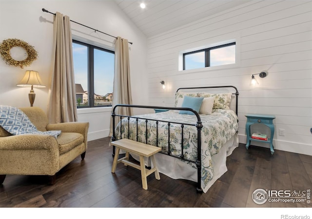 bedroom featuring dark wood-type flooring, vaulted ceiling, and wooden walls