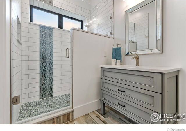 bathroom with vanity, a shower with door, and hardwood / wood-style flooring