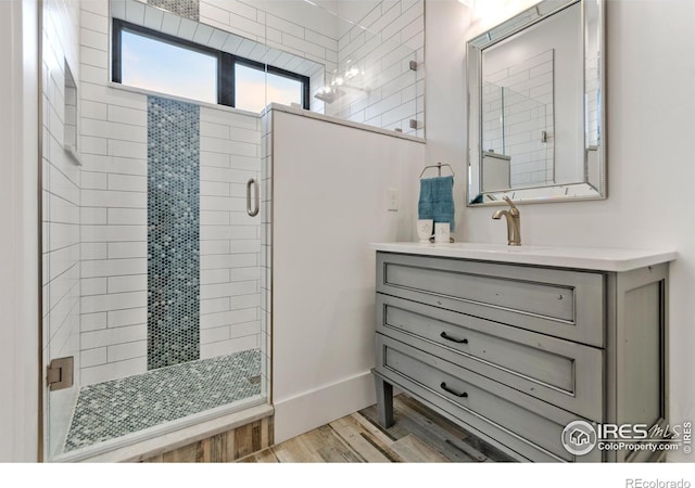 bathroom featuring a shower with door, vanity, and wood-type flooring