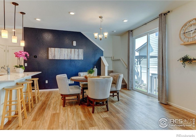 dining space featuring light hardwood / wood-style floors and a chandelier