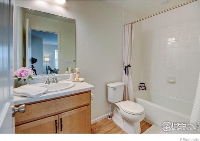 full bathroom featuring hardwood / wood-style flooring, vanity, shower / bathtub combination with curtain, and toilet