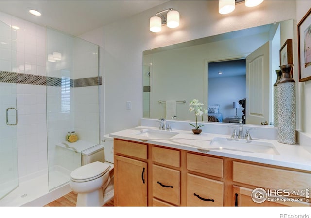 bathroom featuring vanity, toilet, and a shower with shower door