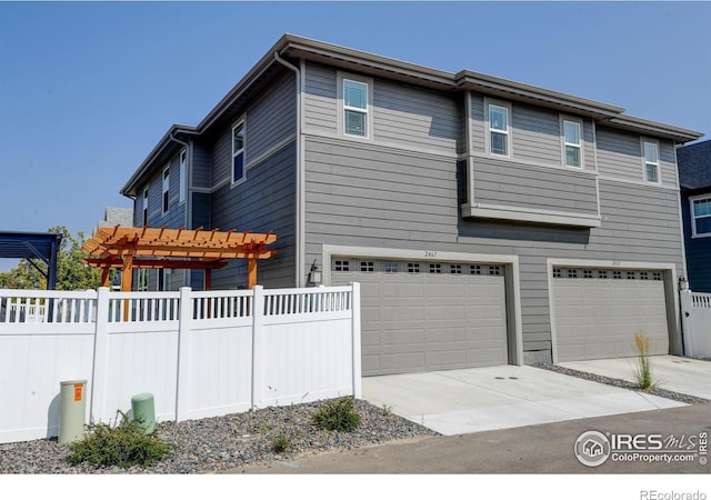 view of side of property featuring a garage and a pergola