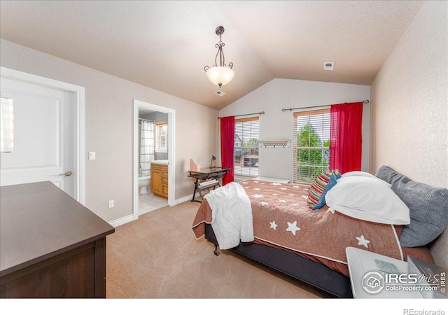 carpeted bedroom with lofted ceiling and ensuite bath