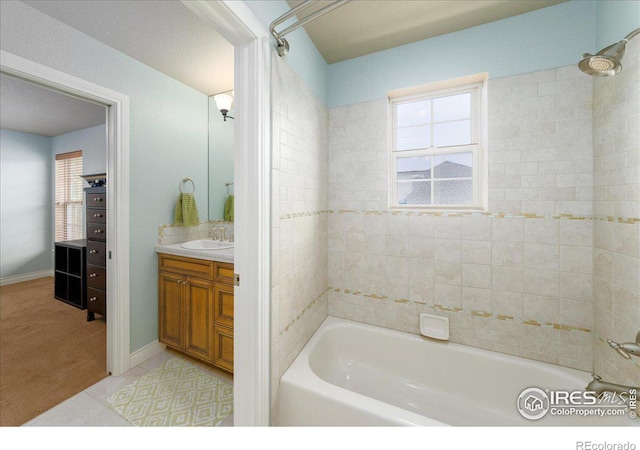 bathroom with tile patterned floors, vanity, and tiled shower / bath combo