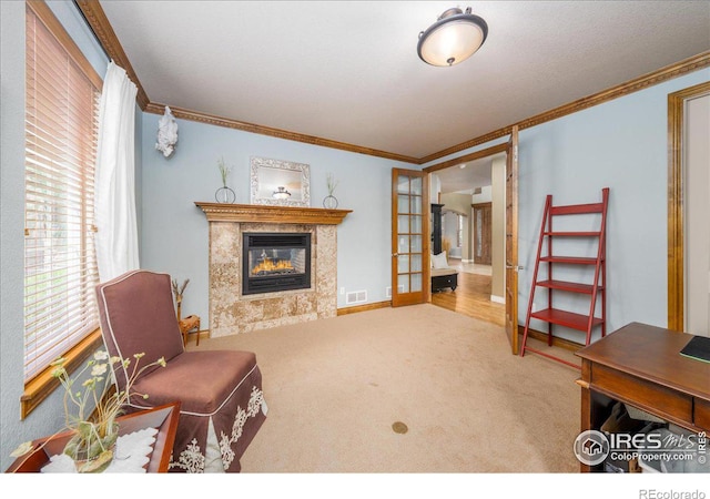 living room with a fireplace, crown molding, french doors, and carpet