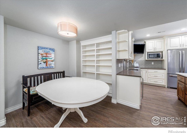 dining room with dark hardwood / wood-style flooring and sink