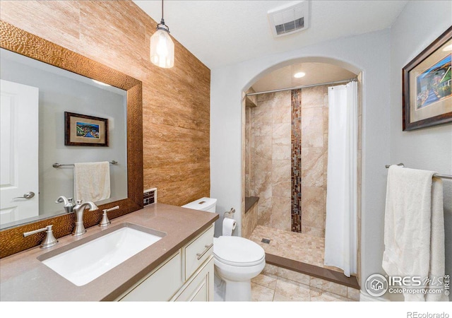 bathroom with vanity, wooden walls, a shower with curtain, and toilet