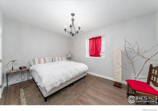 bedroom featuring a chandelier and dark hardwood / wood-style floors