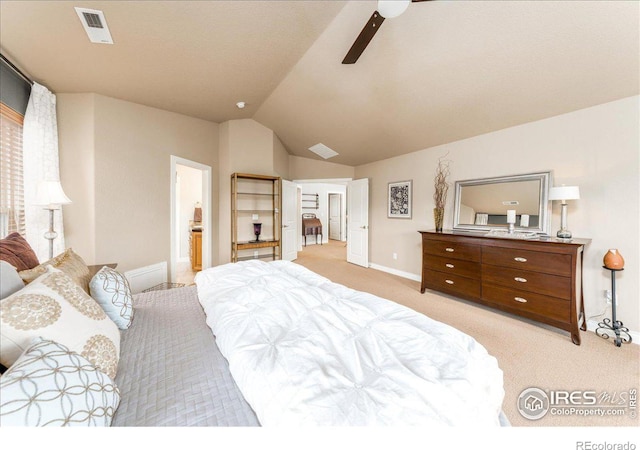 bedroom featuring ceiling fan, ensuite bathroom, light colored carpet, and lofted ceiling